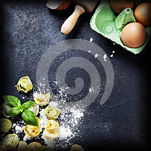 Homemade raw Italian tortellini and basil leaves