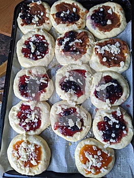 Homemade raw Kolachi pastry with jam and cream cheese filling proofing on a baking pan photo
