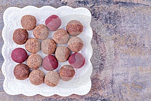 Homemade Raw Vegan Cacao Energy Balls on White Plate on Gray Marble Background