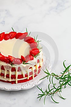 Homemade red velvet cake with white chocolate, fresh strawberries and rosemary