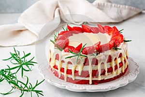 Homemade red velvet cake with white chocolate, fresh strawberries and rosemary