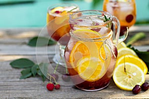 Homemade refreshing drink. Wine sangria or punch with fruits in glasses, cocktails with fresh fruits, berries and rosemary.