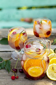 Homemade refreshing drink. Wine sangria or punch with fruits in glasses, cocktails with fresh fruits, berries and rosemary.