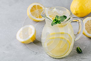 Homemade refreshing summer lemonade drink with lemon slices, ginger and ice