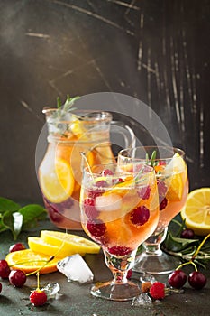 Homemade refreshing wine sangria or punch with fruits in glasses. Sangria cocktails with fresh fruits, berries and rosemary.