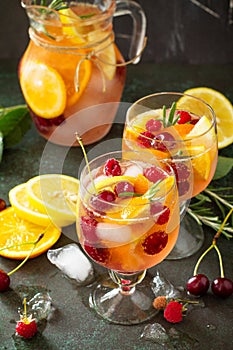 Homemade refreshing wine sangria or punch with fruits in glasses. Sangria cocktails with fresh fruits, berries and rosemary.