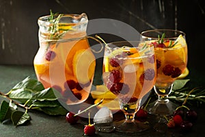 Homemade refreshing wine sangria or punch with fruits. Sangria cocktails with fresh fruits, berries and rosemary.
