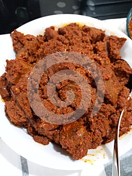 Homemade rendang on a plate. Rendang is indonesian traditional food, made from beef, coconut milk, spices and herbs