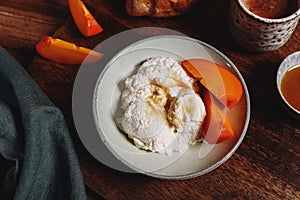 Homemade ricotta cheese or cheese curd served with fresh persimmon and honey