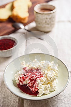 Homemade ricotta soft cheese or cottage cheese served with raspberry jam