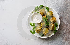 Homemade roasted falafel balls with greens and yogurt sauce