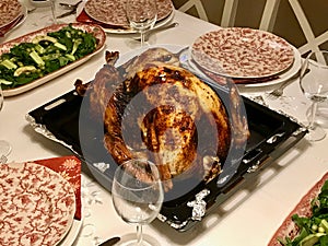 Homemade Roasted Thanksgiving Day Turkey with all the Sides at Dinner Table.