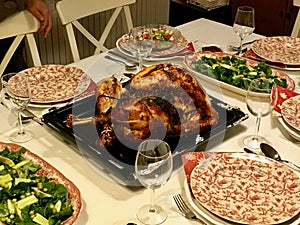 Homemade Roasted Thanksgiving Day Turkey with all the Sides at Dinner Table.