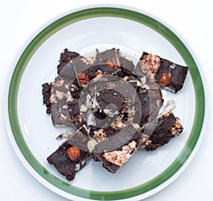 Homemade Rocky road chocolate on white plate with green trim on