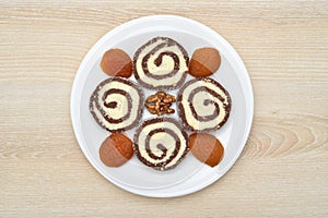 Homemade roll cake dessert on the white plate on the brown wooden table