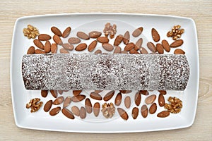 Homemade roll cake dessert on the white tray on the brown wooden table