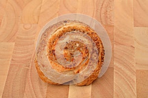 Homemade roll of puff pastry with nuts on wooden background. Sweet pastry. Selective focus