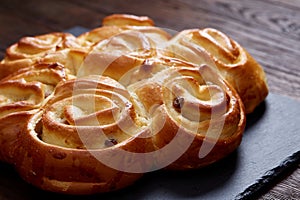 Homemade rose bread on black cutting board on vintage background, close-up, shallow depth of field