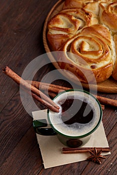 Homemade rose bread, cup of coffee, anise and cinnamon on vintage background, close-up, selective focus