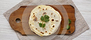 Homemade Roti Chapati Flatbread on a rustic wooden board, top view. Overhead, from above, flat lay