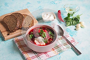 Homemade Russian, Ukrainian and Polish national soup - red borscht made of beetrot, vegetables and meat with sour cream.