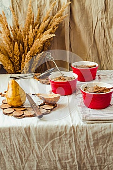 Homemade rustic apple and pear oatmeal crumble in portion of red