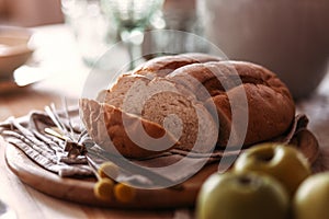 Homemade rustic bread loaf with slices on wooden background