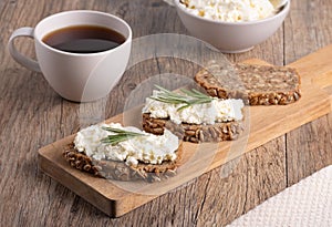 Homemade rye bread with cottage cheese in a plate and coffee. Healthy breakfast concept