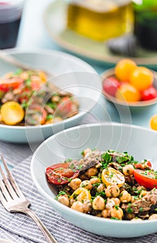 Homemade  salad with chickpea, roast beef and cherry tomatoes with red wine on a acqua surface daylight