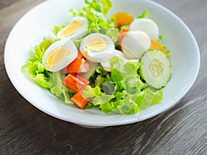 Homemade salad with fresh vegetables, crab stick, eggs