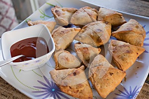 Homemade samosa indian snack top view with white dish and chutney