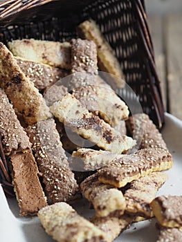 Homemade sandwich puff pastry chocolate cookies in a wicker natural basket of vines. Wooden ancient table