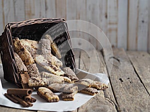 Homemade sandwich puff pastry chocolate cookies in a wicker natural basket of vines. Wooden ancient table