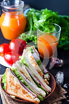 Homemade sandwich with salad and juice as a healthy breakfast