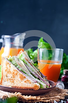 Homemade sandwich with salad and juice as a healthy breakfast