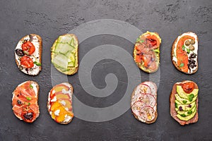 Homemade sandwiches with bread and various ingredients and spices on a dark background. Healthy delicious food for