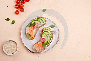 Homemade sandwiches with rye bread with salted salmon, avocado, fresh tomatoes
