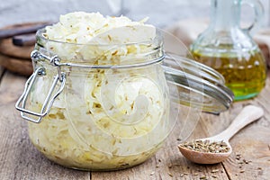 Homemade sauerkraut with cumin in a glass jar photo