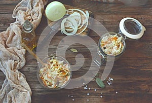 Homemade sauerkraut in glass bowl on a wooden table, top view