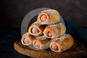 Homemade sausages baked in dough  pigs in blankets on a dark background, fast street food