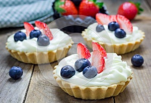 Homemade shortbread tartlets with custard cream, strawberry and blueberry