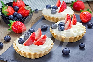 Homemade shortbread tartlets with custard cream, strawberry and blueberry