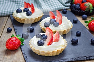 Homemade shortbread tartlets with custard cream, strawberry, blueberry