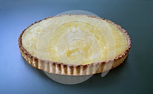 Homemade shortcrust pastry lemon pie on turquoise background.