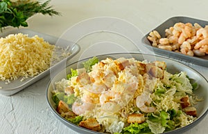 Homemade Shrimp Caesar Salad with parmesa, sauce and Croutons on a white background