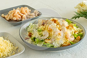 Homemade Shrimp Caesar Salad with parmesa, sauce and Croutons on a white background