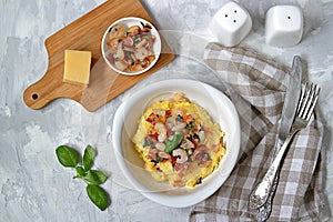 Homemade shrimp and grits with bacon, Chedder cheese and parsley in a white bowl. American cuisine