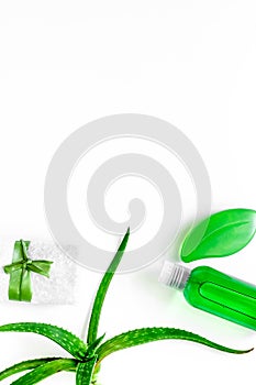 Homemade skin care. Aloe vera leafs, glass of aloe vera juice and soap on white background top view copyspace