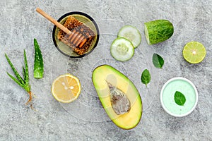 Homemade skin care and body scrub with natural ingredients avocado ,aloe vera ,lemon,cucumber and honey set up on stone