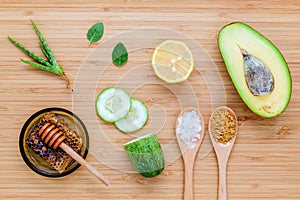 Homemade skin care and body scrub with natural ingredients avocado ,aloe vera ,lemon,cucumber and honey set up on wooden